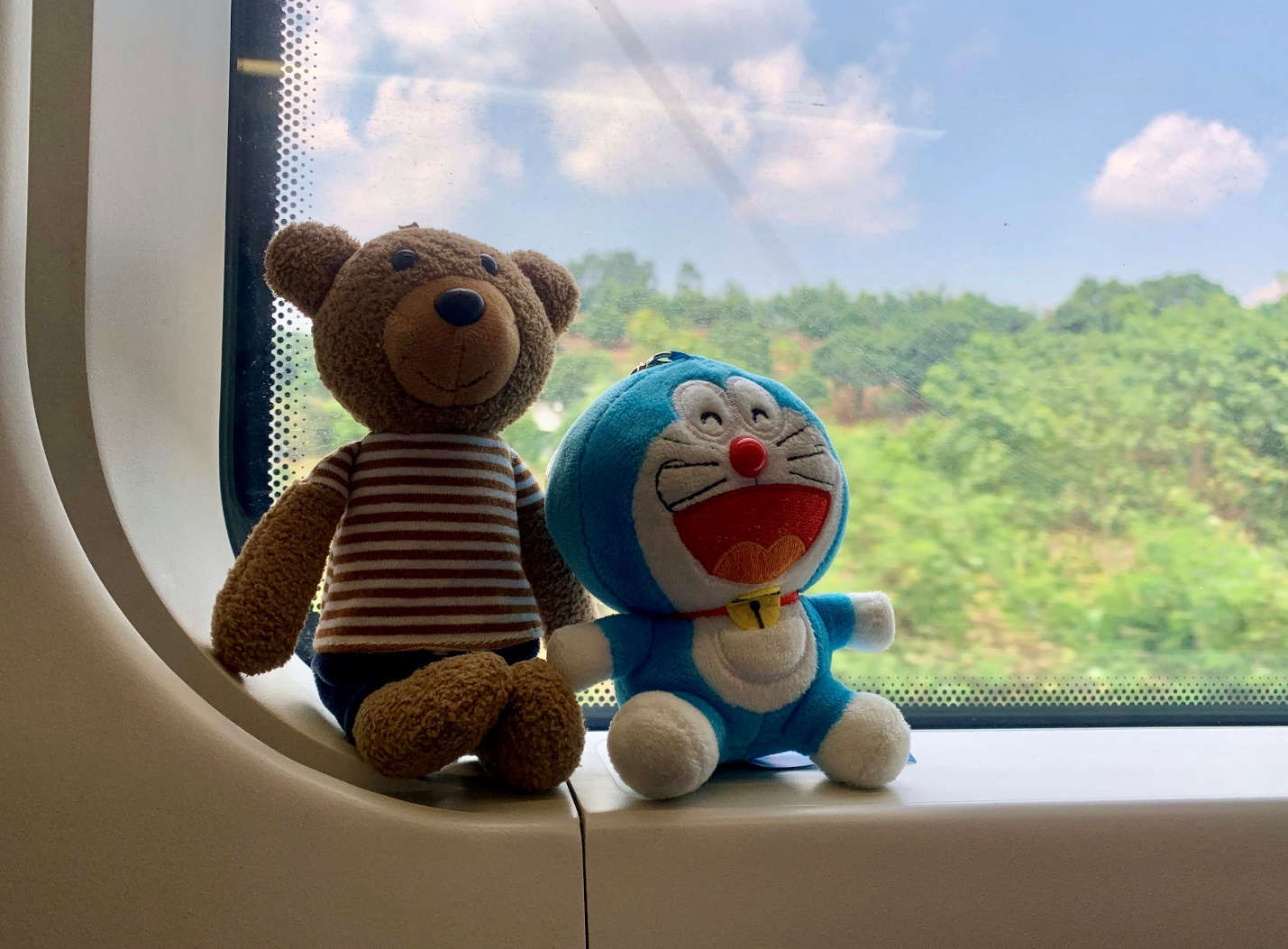 a couple of stuffed animals sitting on top of a window sill