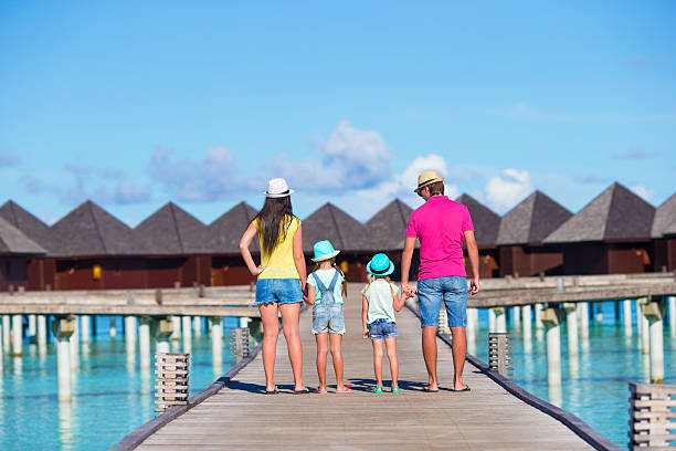 Beautiful family on summer vacation Beautiful family of four on beach during summer vacation Family-Friendly Destinations for a Perfect Vacation stock pictures, royalty-free photos & images