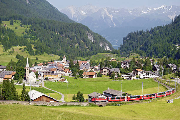 Bernina Express just outside Bergün The Bernina Express from the Rhaetian Railway near the railway station of Bergün. This railway station is located on the Albula Railway line from Chur to St. Moritz. The Bernina Express is connecting Chur in Switzerland and Tirano in Italy. the train runs along the World Heritage Site known as the Rhaetian Railway in the Albula / Bernina Landscapes. Bernina Express Switzerland stock pictures, royalty-free photos & images