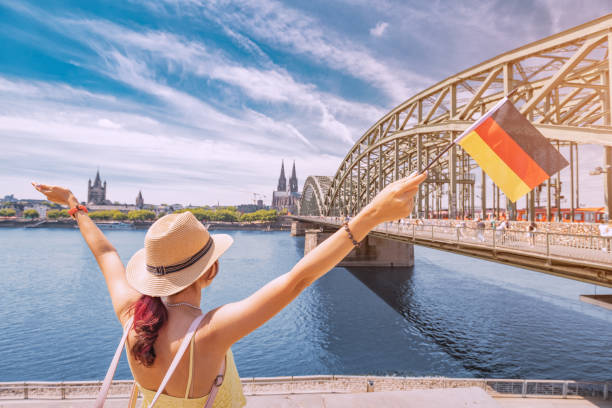 Happy girl holding a German flag against the Rhine bridge and Cologne Dom Cathedral. Travel landmarks and traditional holidays Happy girl holding a German flag against the Rhine bridge and Cologne Dom Cathedral. Travel landmarks and traditional holidays Safest Countries for Female Solo Travelers stock pictures, royalty-free photos & images
