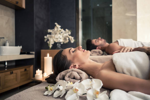 Man and woman lying down on massage beds at Asian wellness center Young man and woman lying down on massage beds at Asian luxury spa and wellness center Spa Retreats and Relaxation stock pictures, royalty-free photos & images