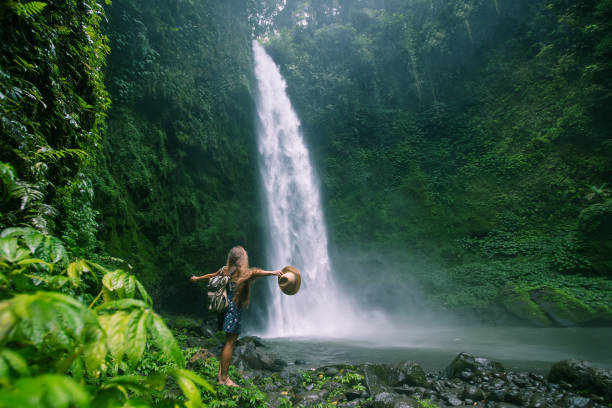 Woman near Nung Nung waterfal on Bali, Indonesia Woman near Nung Nung waterfal on Bali, Indonesia The laid-back style of Bali, Indonesia stock pictures, royalty-free photos & images